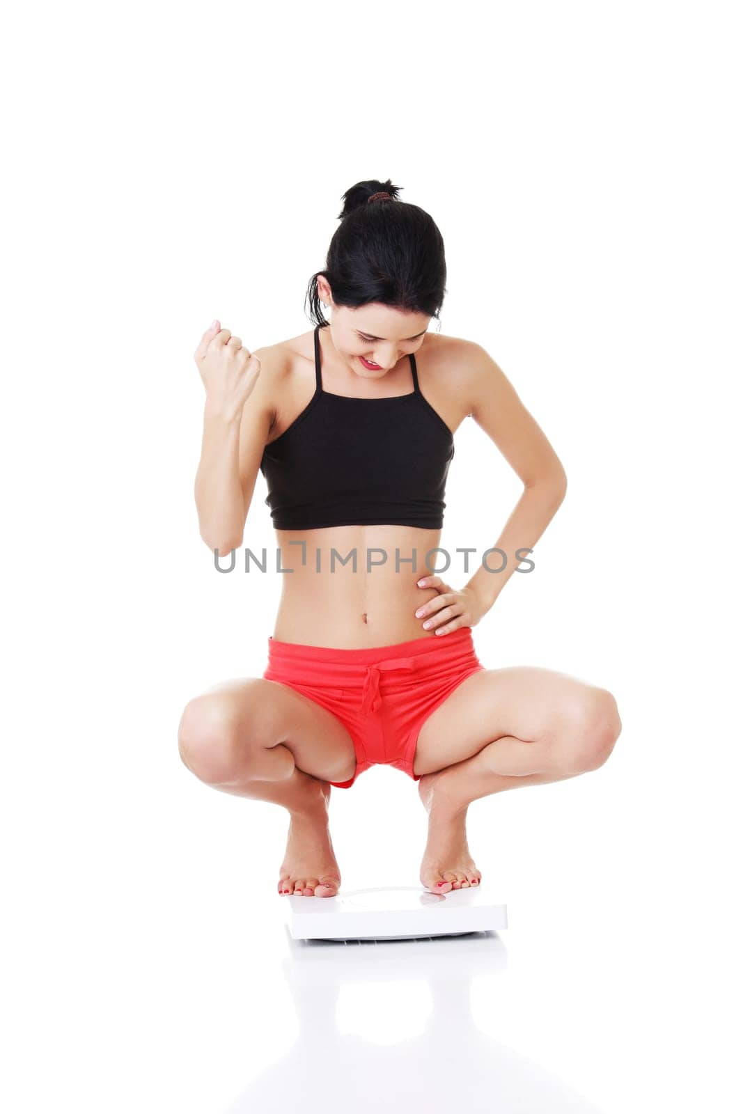 young woman in crouch in sportswear. isolated on white.