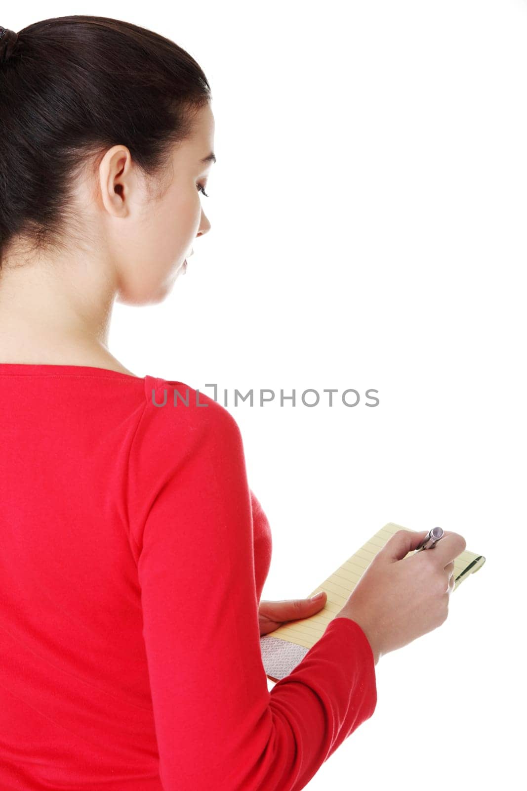 happy casual woman writing on a piece of paper. back view. isolated on white.