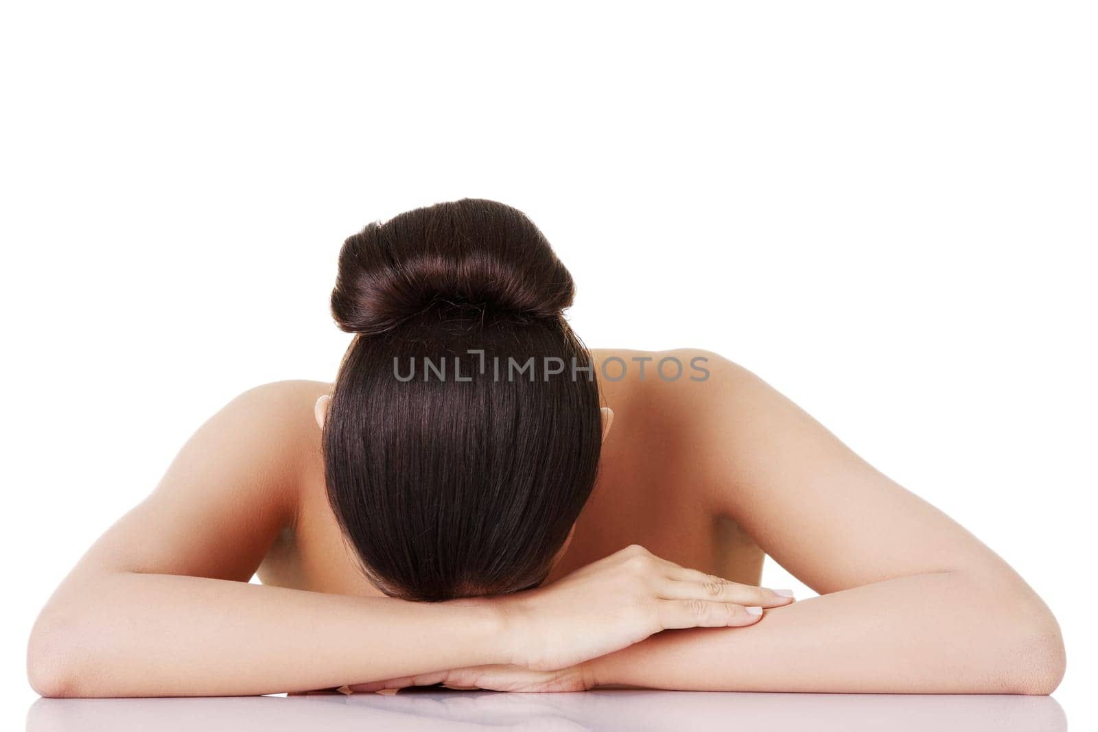 naked woman having her head down on hands. isolated on white.