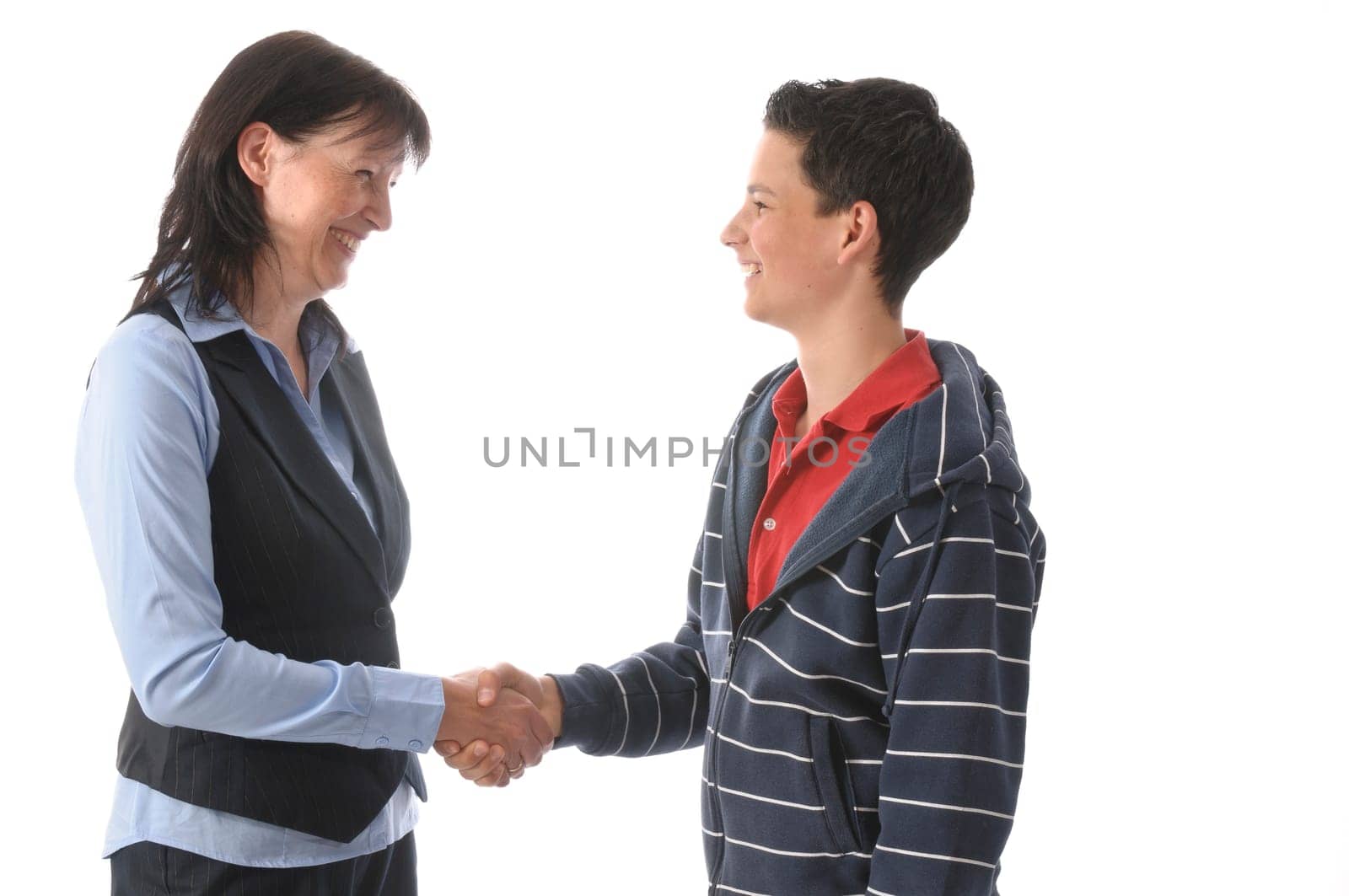 An adult woman shakes hands with her teenage son against a white background.