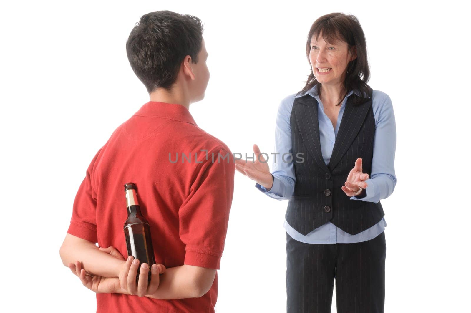 Mother catches her teenage son with a bottle of beer and scolds him against a white background.