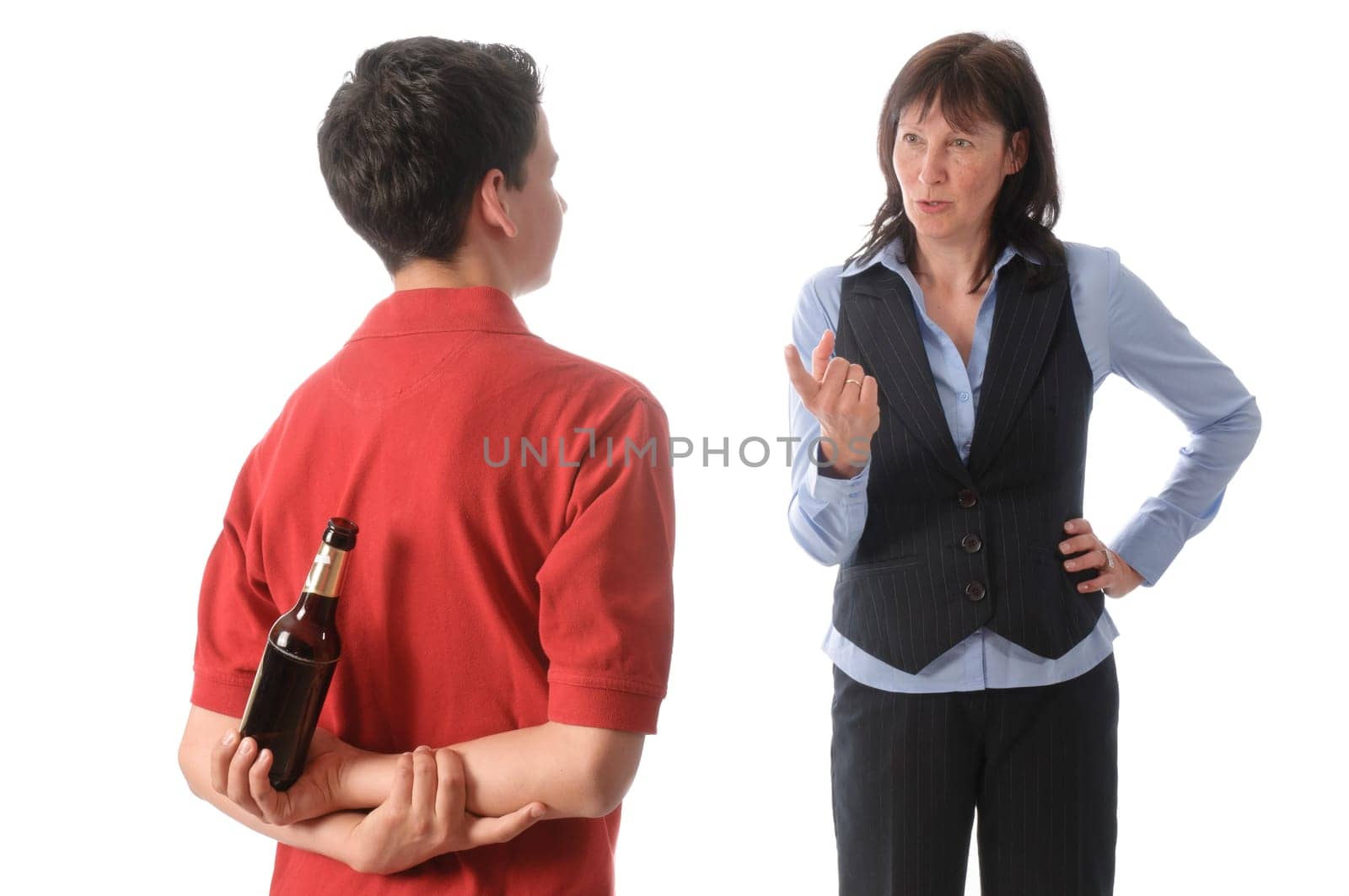 Mother catches her teenage son with a bottle of beer and scolds him against a white background.