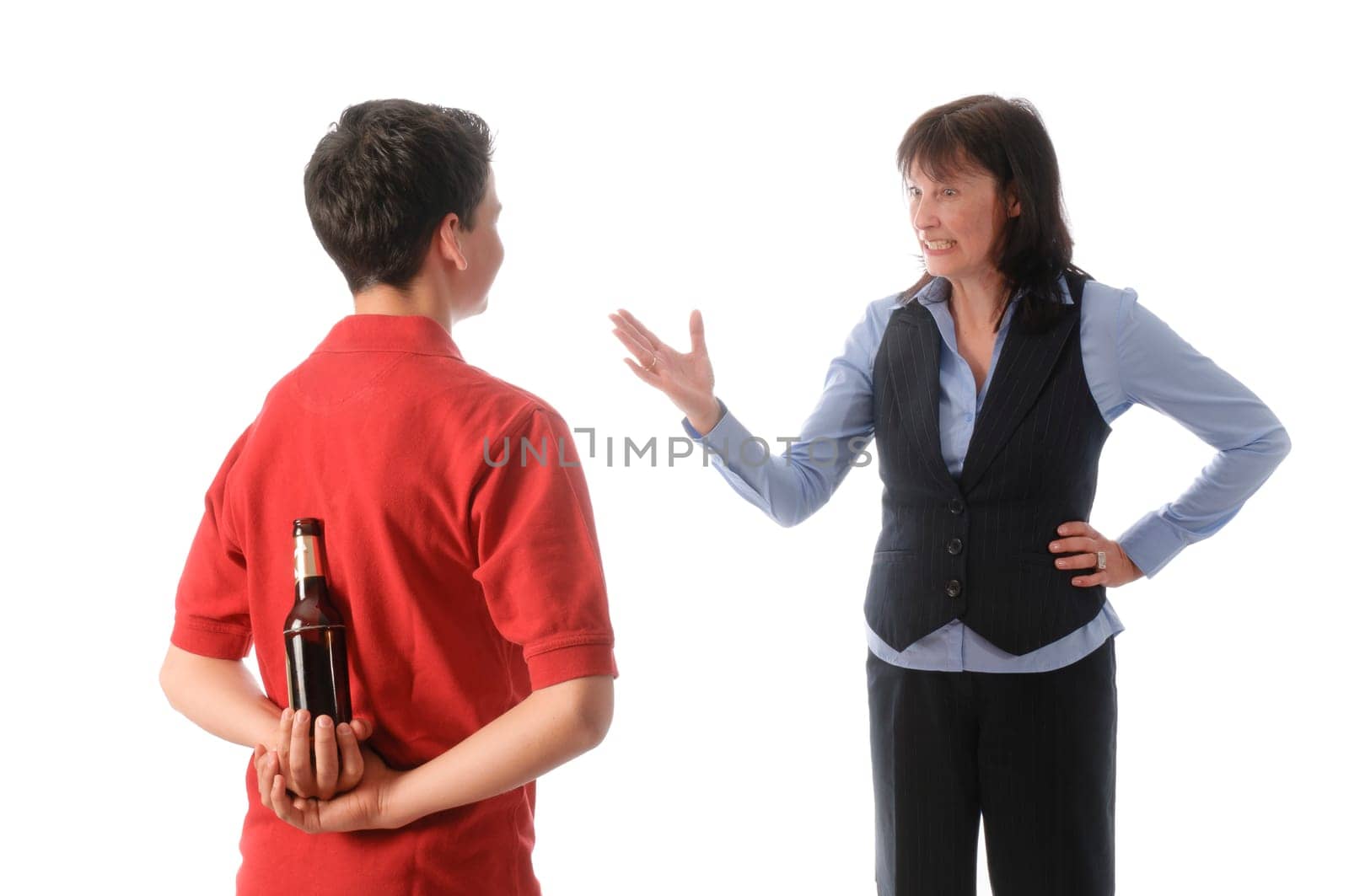 Mother catches her teenage son with a bottle of beer and scolds him against a white background.