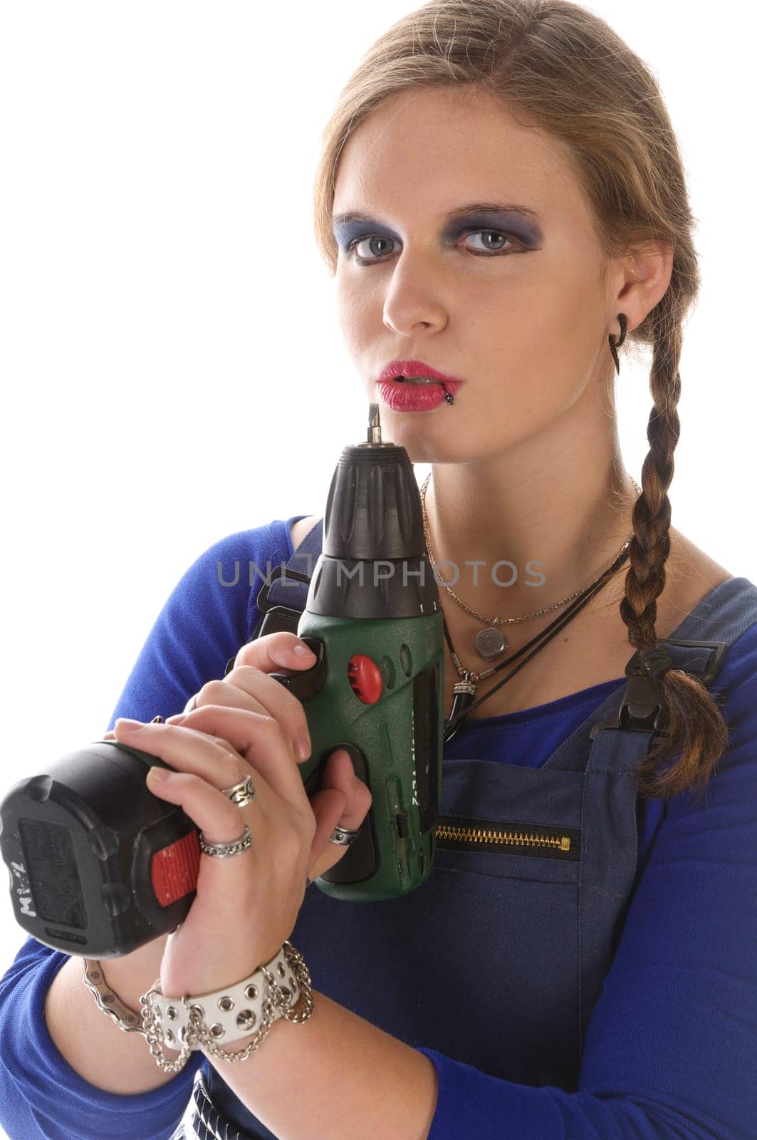 Wildew's teenage girl as a trainee (apprentice) with blue man (work suit) and braids poses with a cordless Borhschrauber against a white background