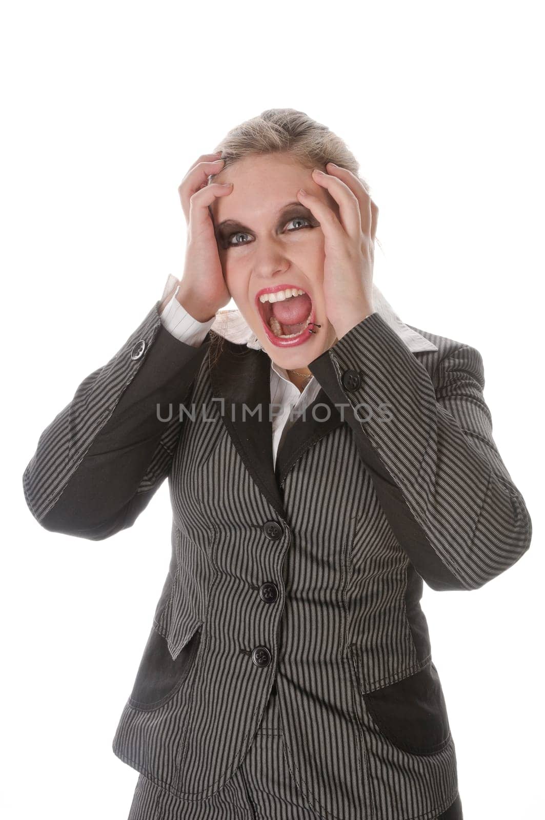 Young woman in grey business suit and high heels is horrified and desperate in front of a white background,portrait