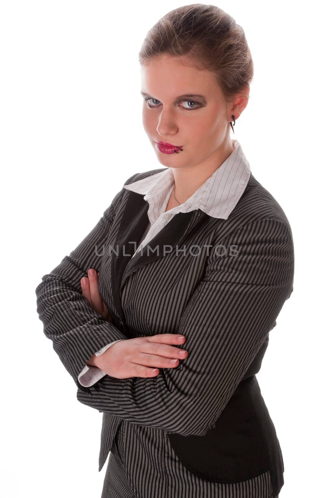 Young woman in grey business suit and high heels poses with folded arms against a white background