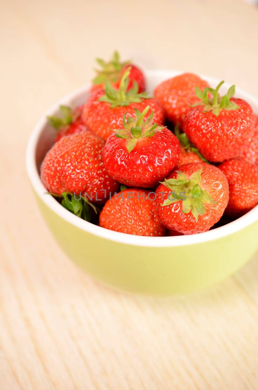 Fresh strawberries in a green bowl