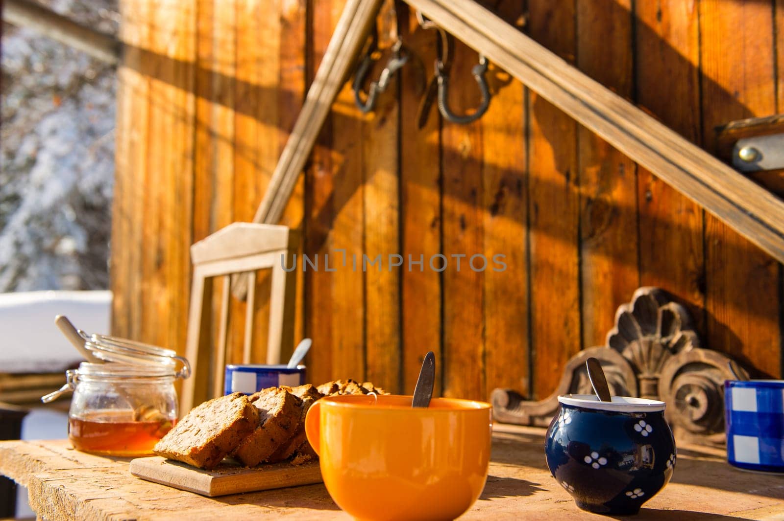 Breakfast on wooden table outside winter snow cottage