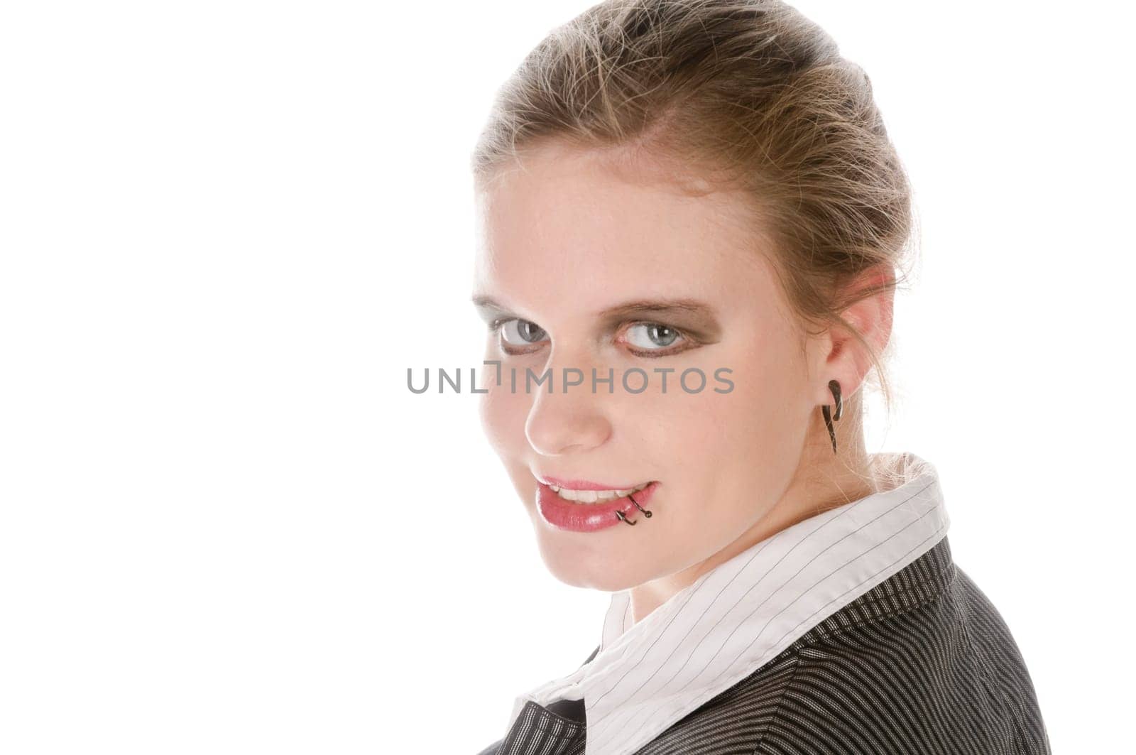 Young woman in grey business suit and high heels looks over her shoulder into the camera against a white background