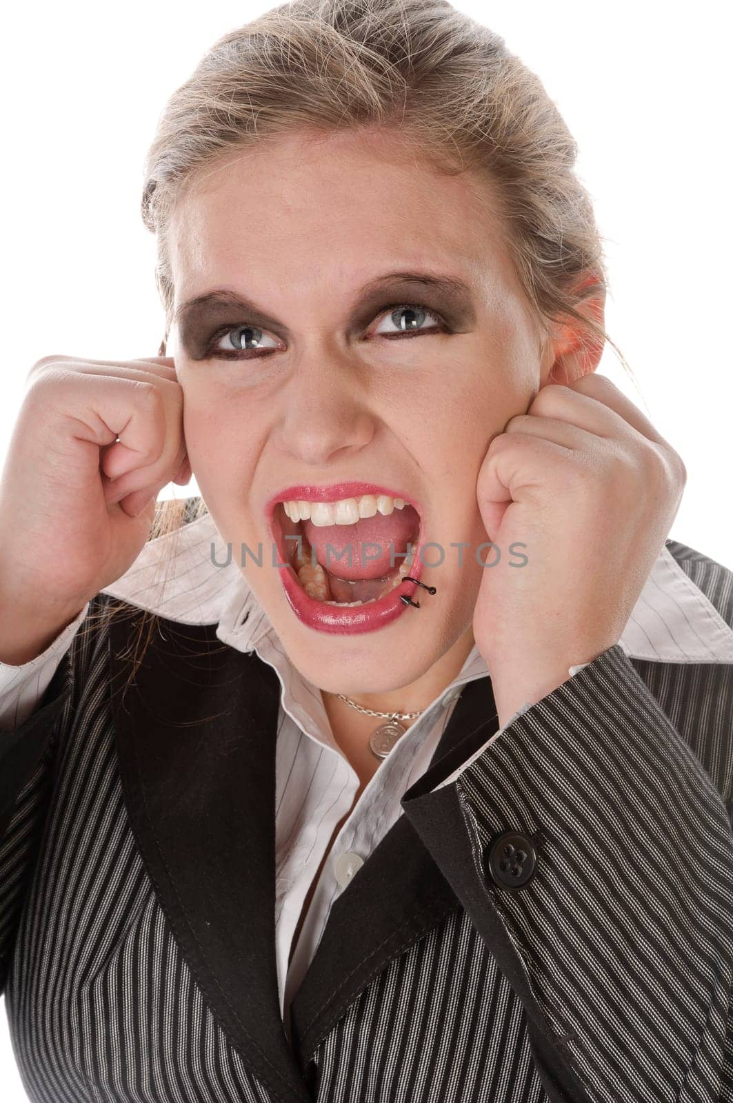 Young woman in grey business suit and high heels is horrified and desperate in front of a white background,portrait