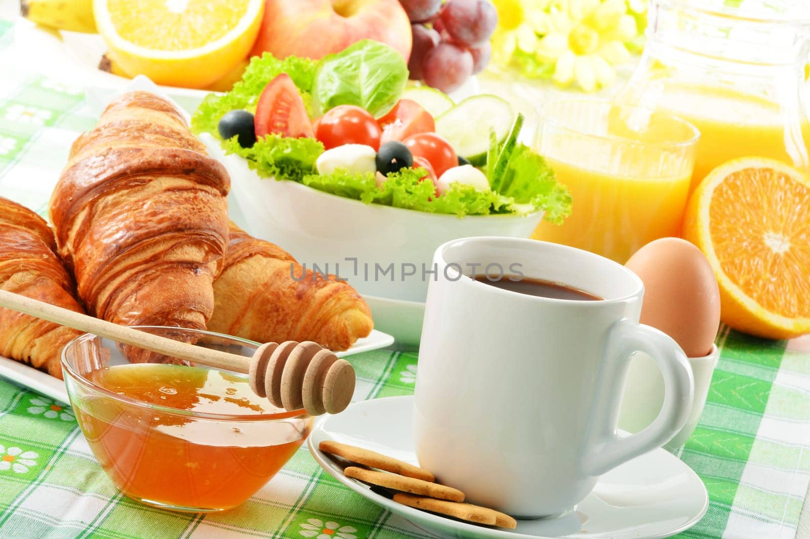 Breakfast with coffee, orange juice, croissant, egg, vegetables and fruits