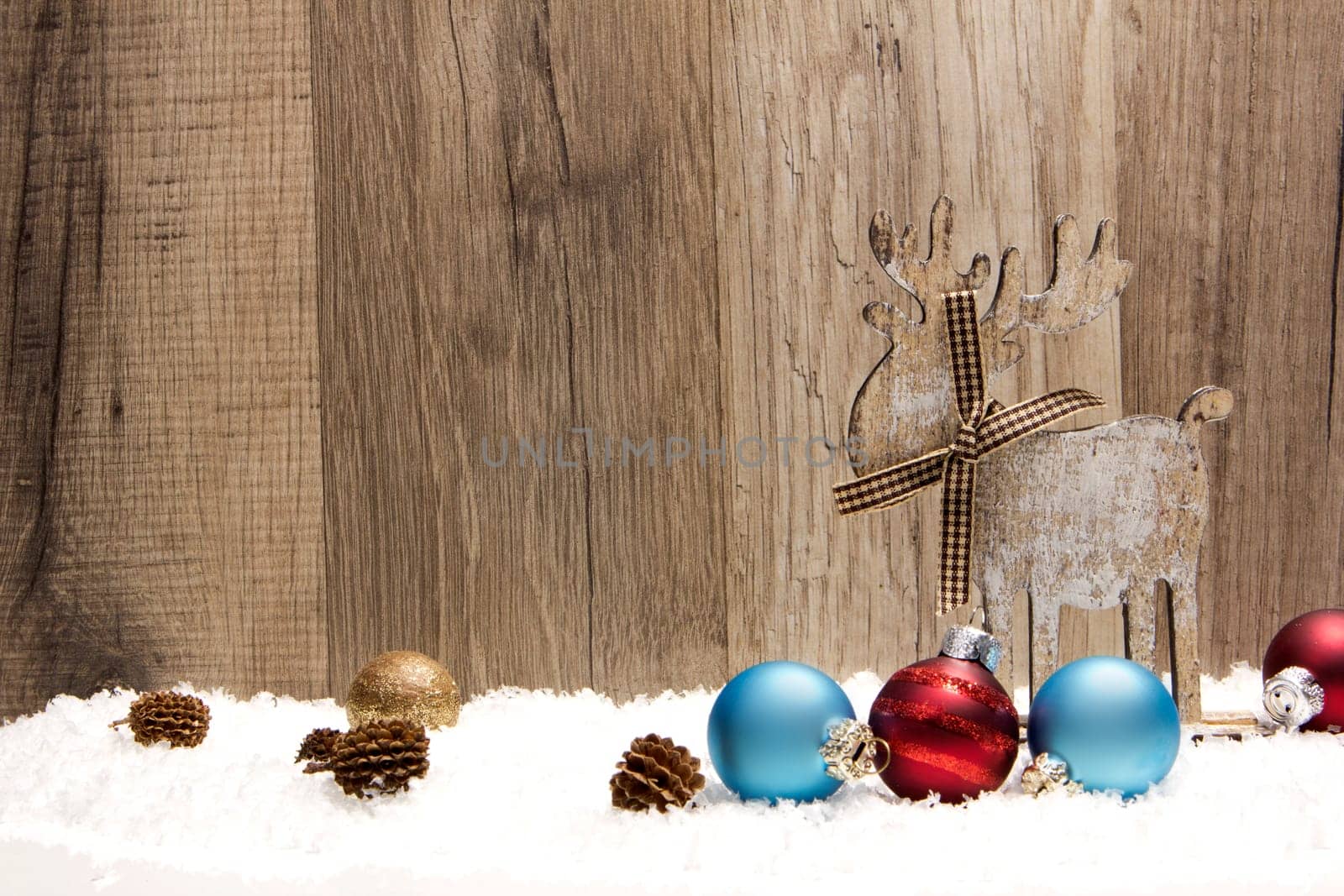 Christmas,decoration with wooden background,snow,moose,Christmas baubles gold,blue and red and pine cones