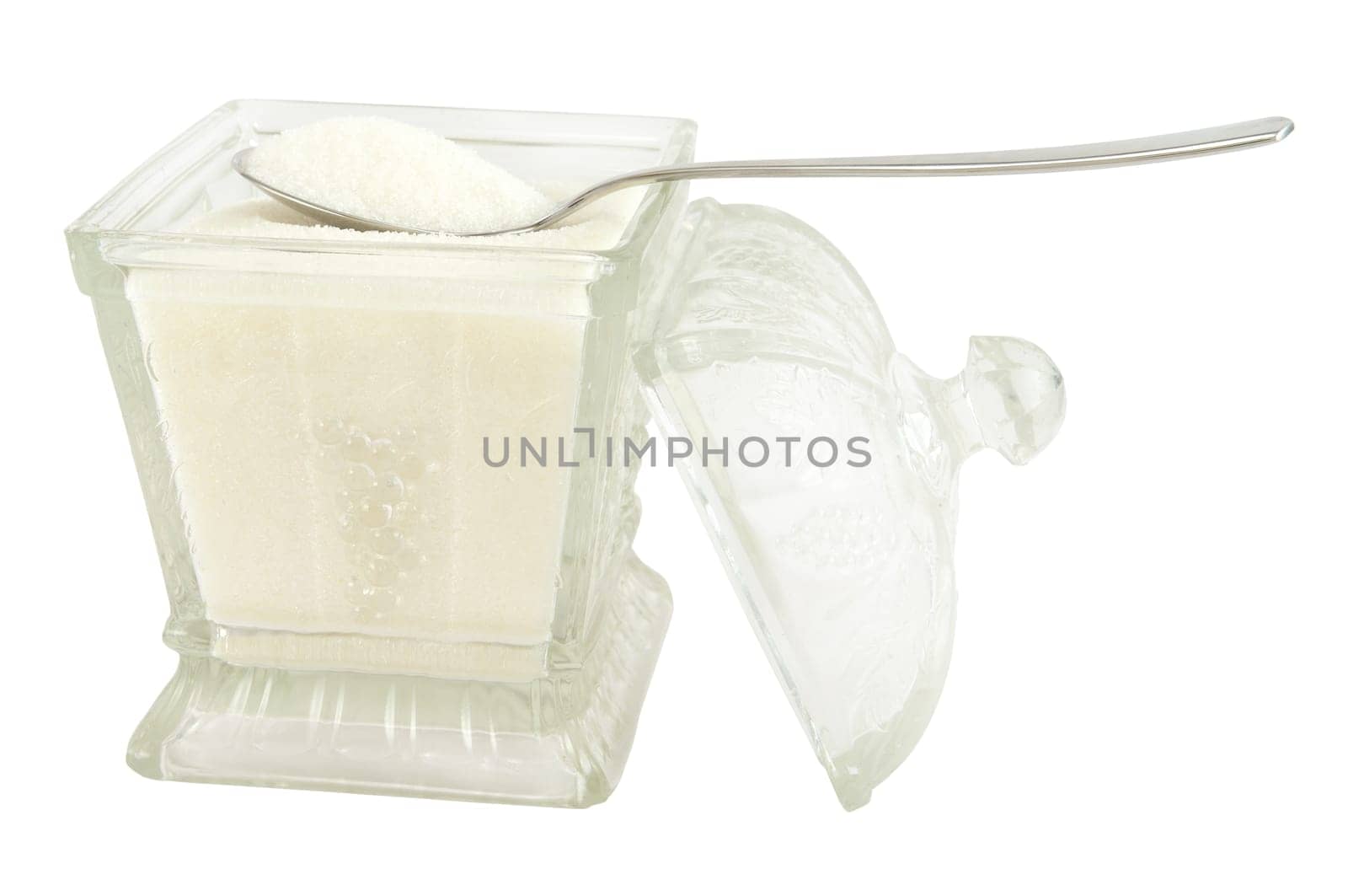 A spoonful of sugar and glass sugar bowl isolated on white.