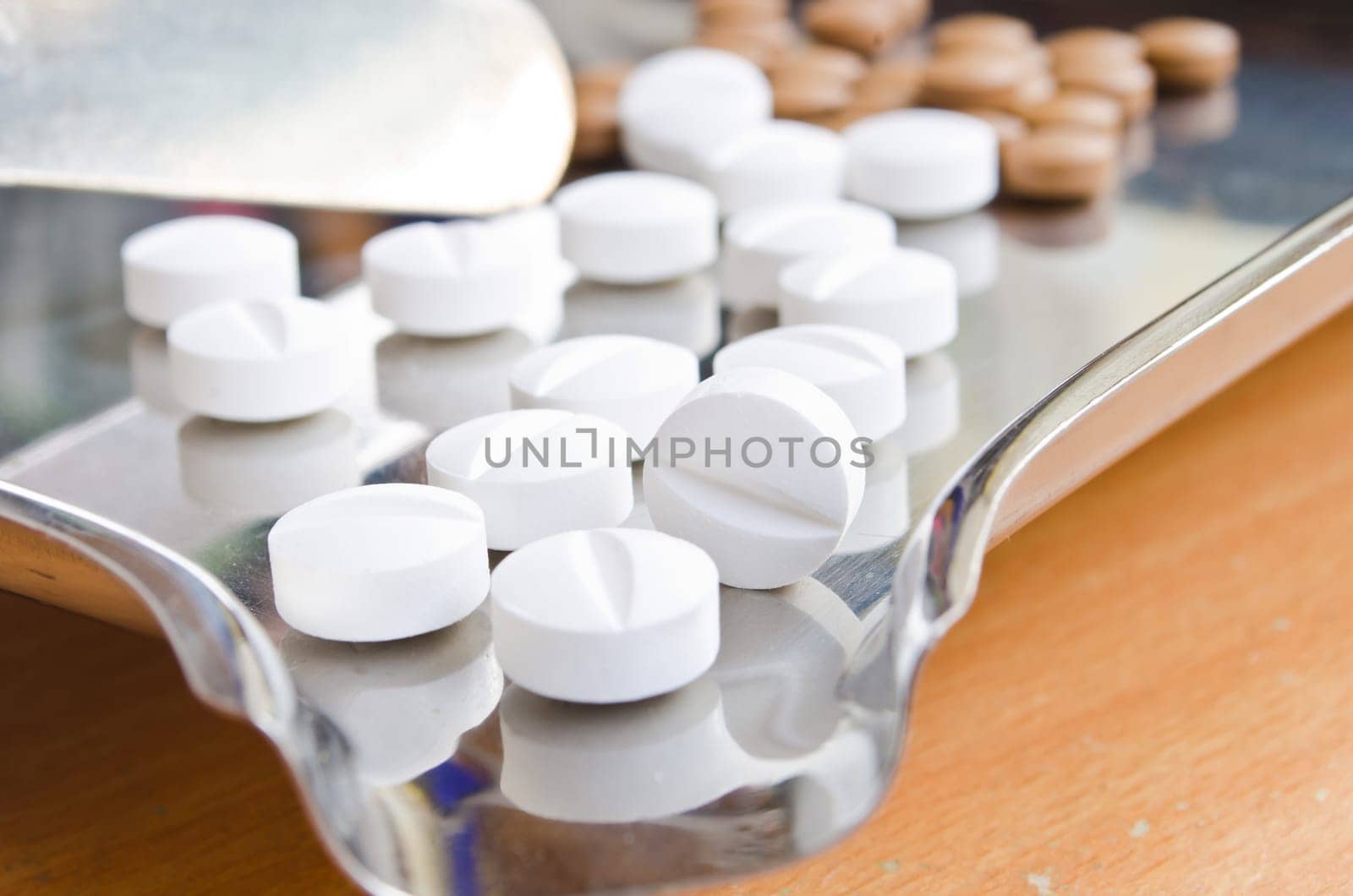 Close up of Counting tablets medical pills on stainless steel tray.(Health care and medical concept)