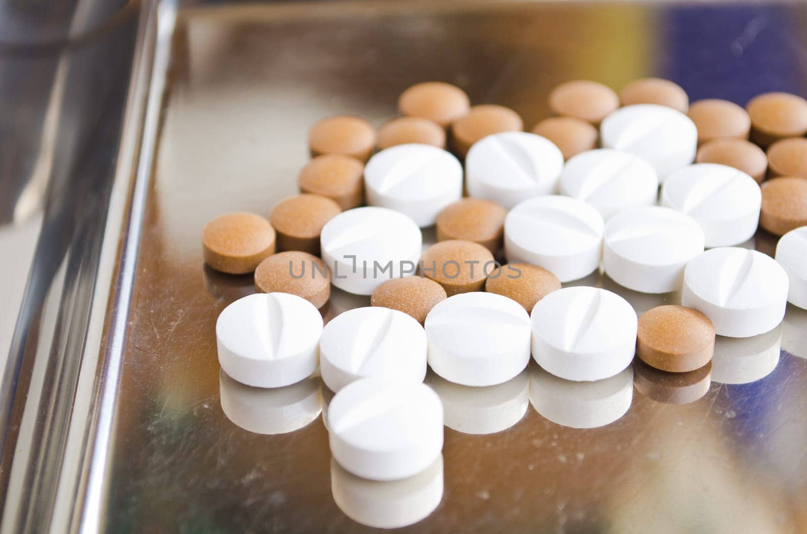 Close up of Counting tablets medical pills on stainless steel tray.(Health care and medical concept)