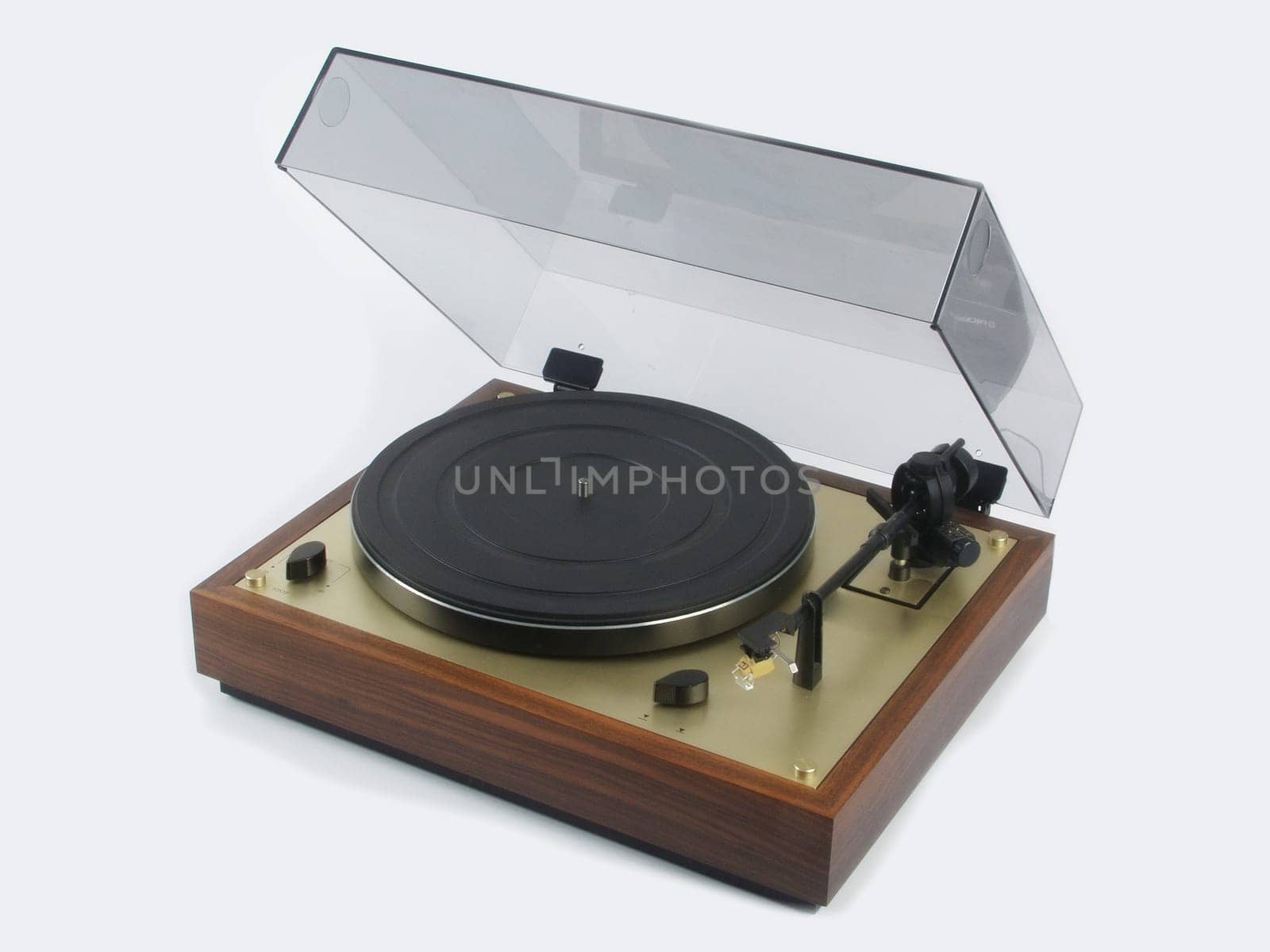 A valuable record player with wooden housing and acrylic lid against a white background