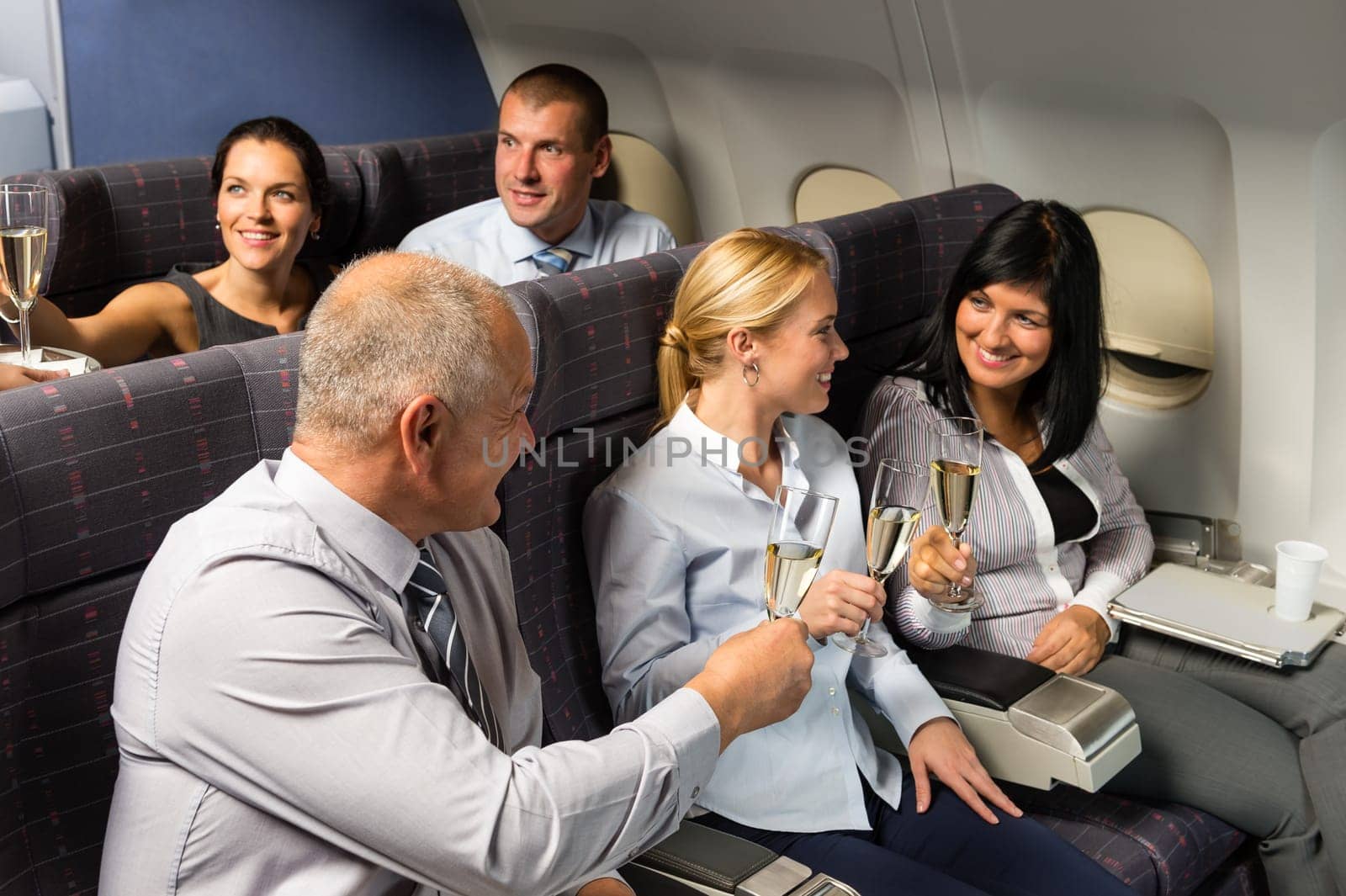 Airplane cabin businesspeople toasting with champagne flight travel passenger