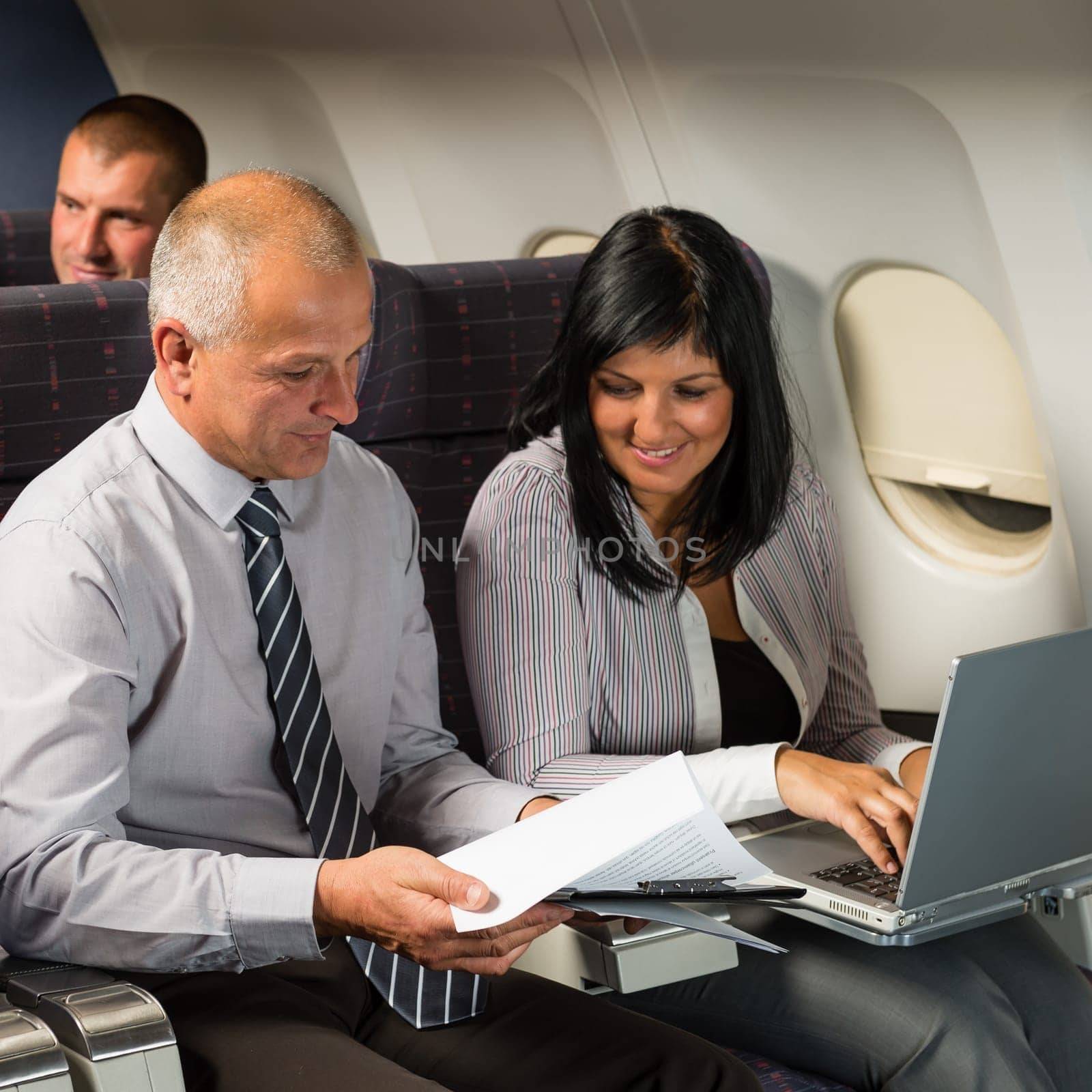 Businesspeople working on computer during flight airplane cabin passenger travel