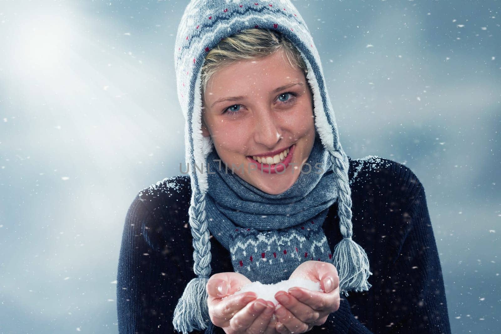 Happy woman in winter with a handful of snow