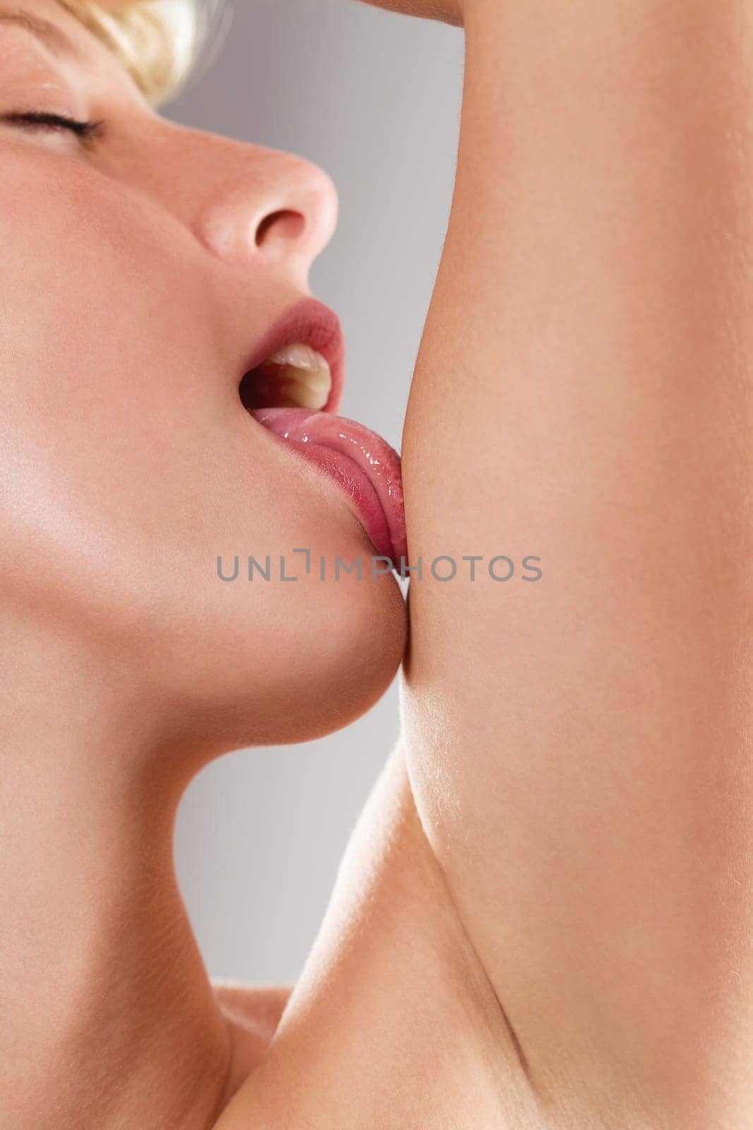 Sensual beautiful woman licks her arm