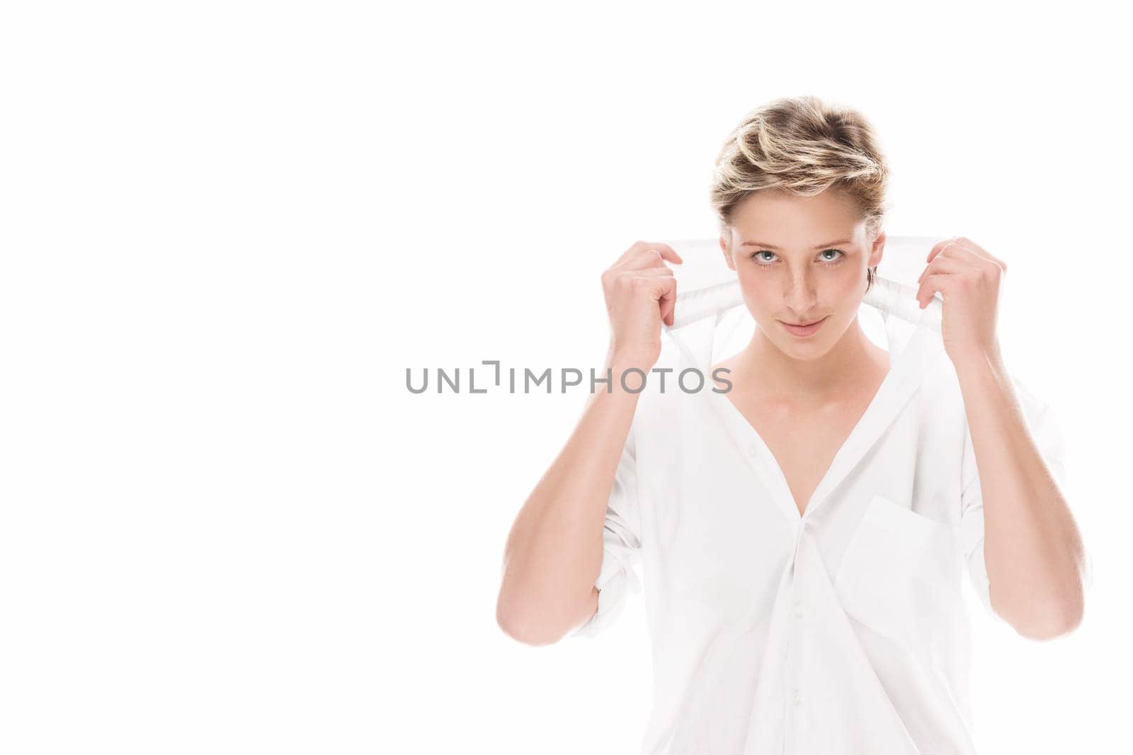 Young woman holds her shirt collar on white background