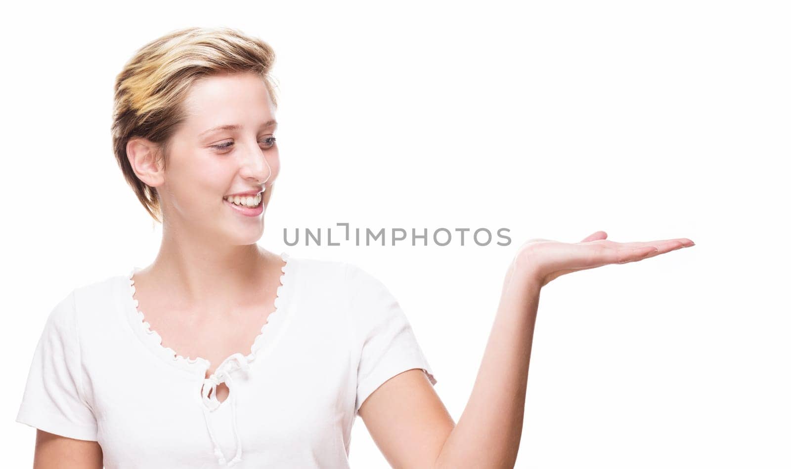 Young woman shows empty hand for product placement on white background