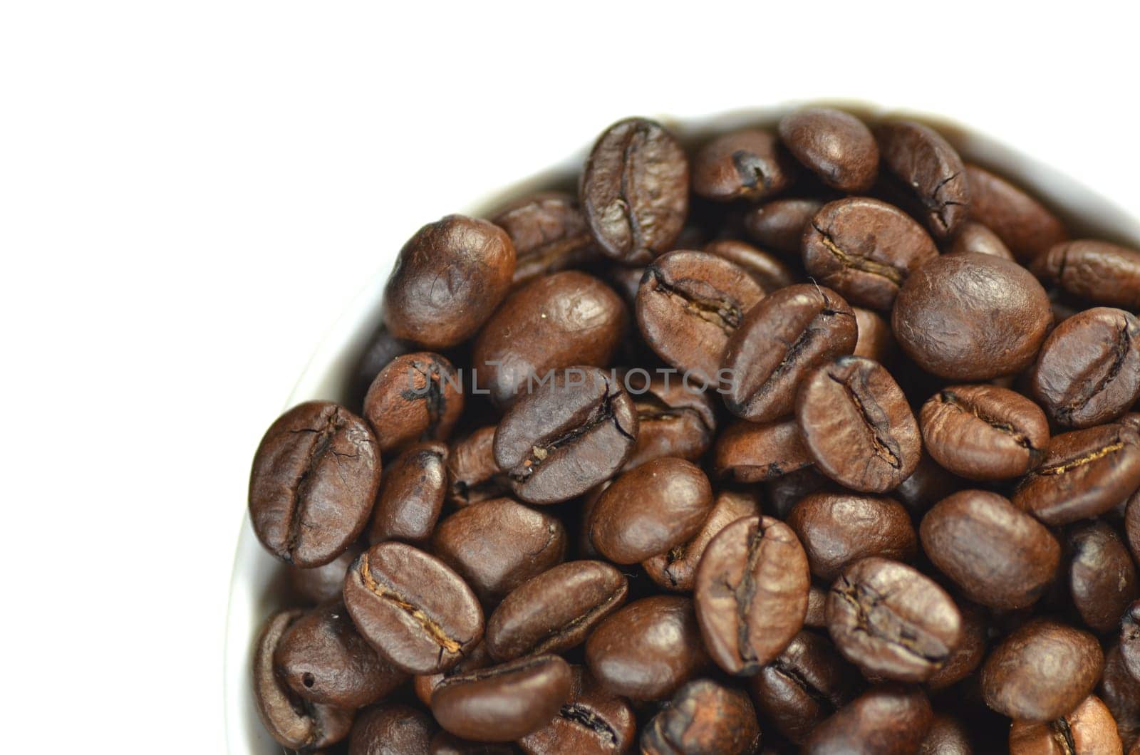 white coffee cup full of coffee beans