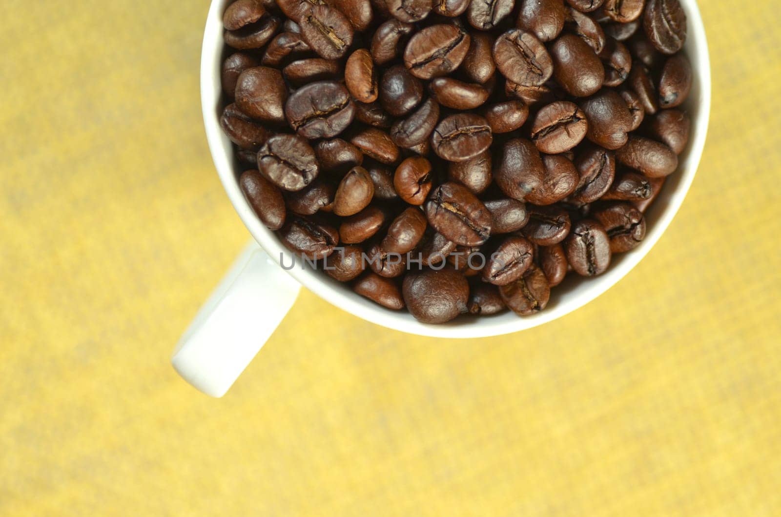 white coffee cup full of coffee beans