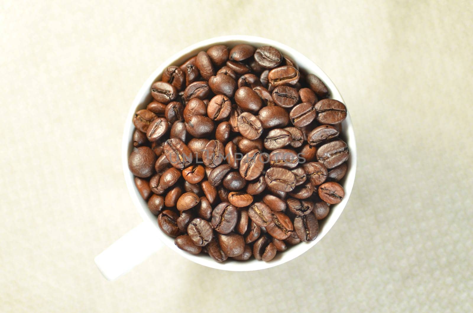 white coffee cup full of coffee beans