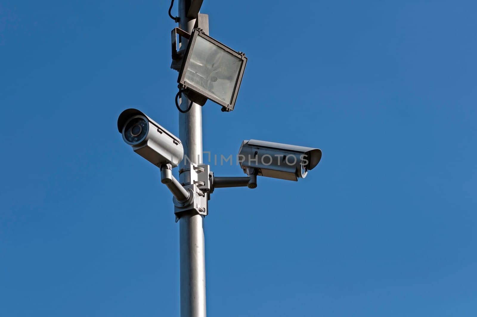 Crime control. Two security cameras monitor a parking lot.