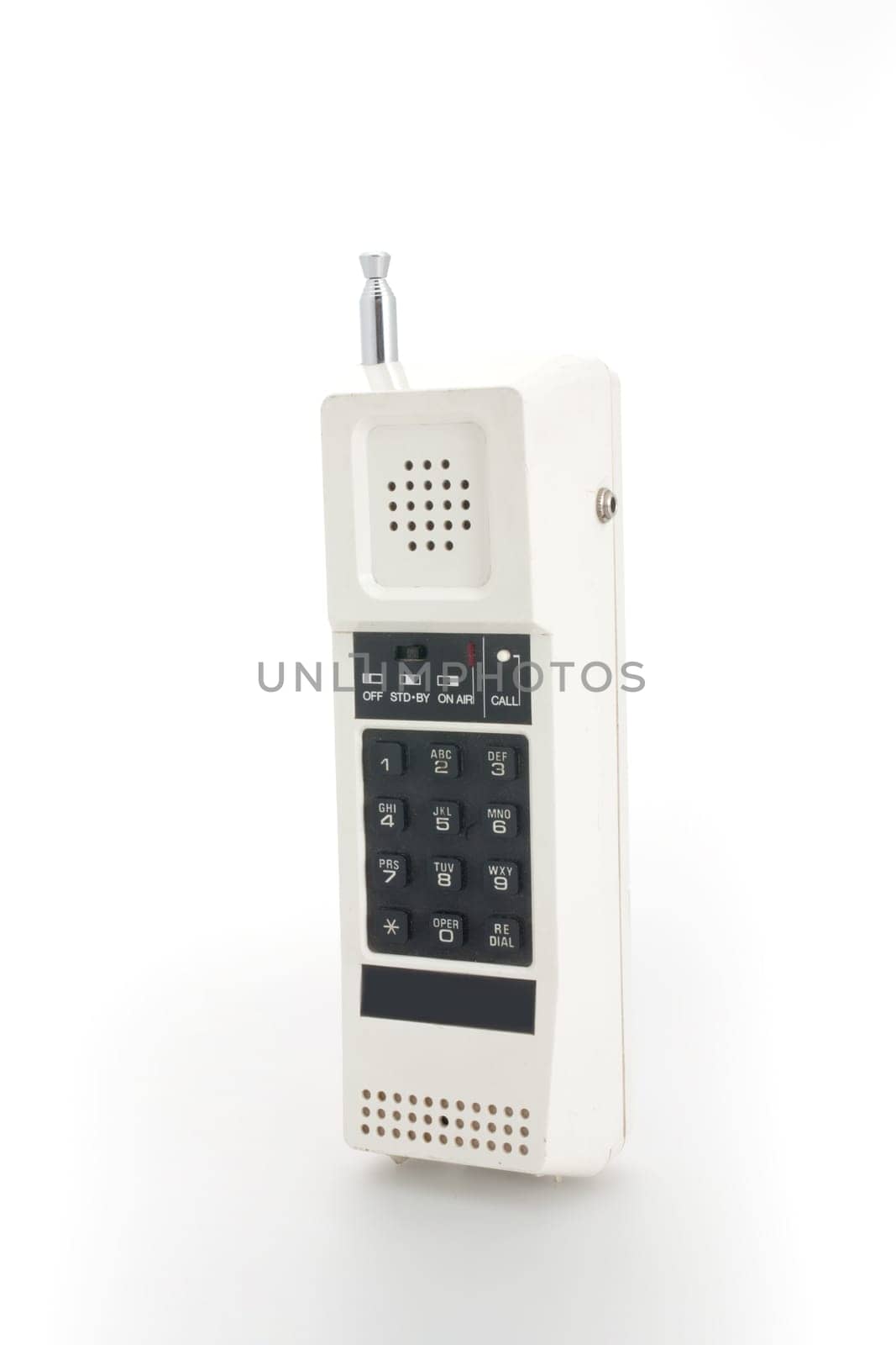 A white cordless telephone from the eigthes with black buttons and a telescopic antenna