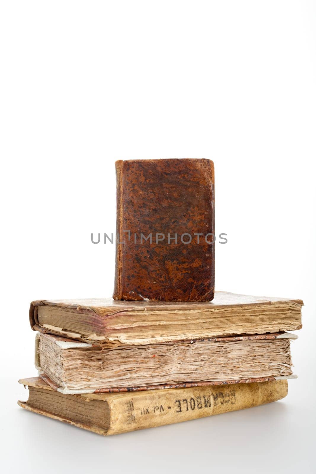 A book standing over three antique books (you can write on the cover of the standing one)