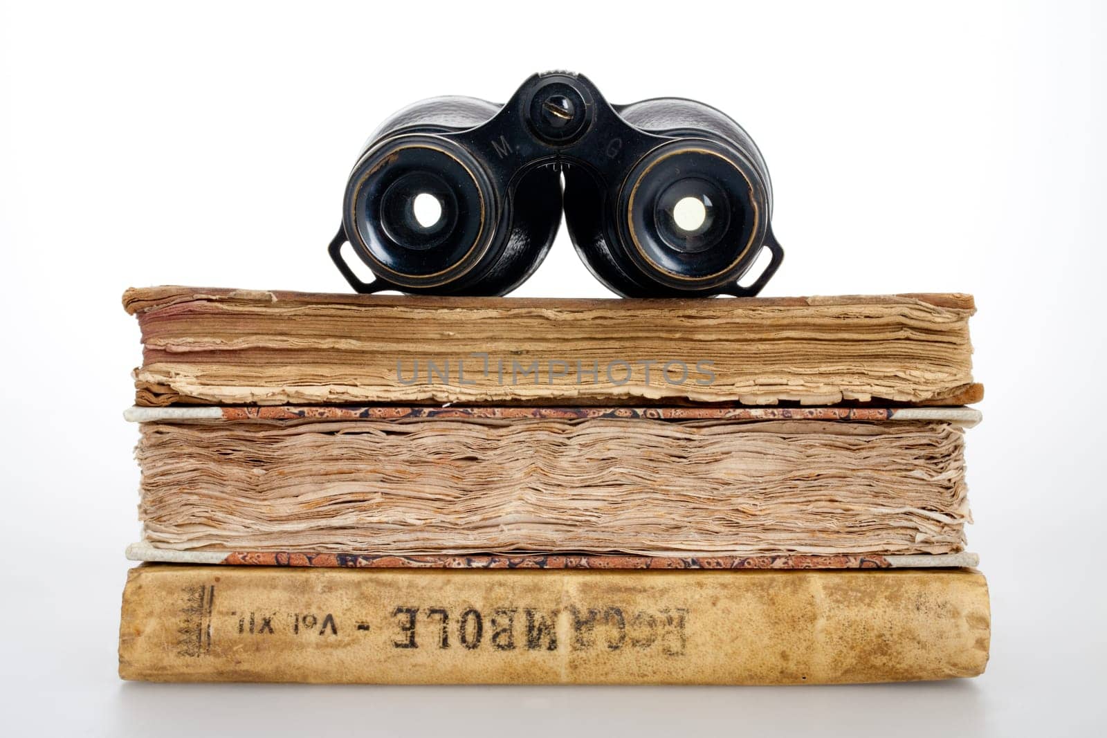 Antique books and binoculars symbolizing adventure and travel book, on a white background
