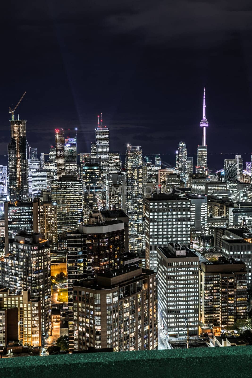Full view of downtown Toronto at night with glamour lights viewing from a balcony