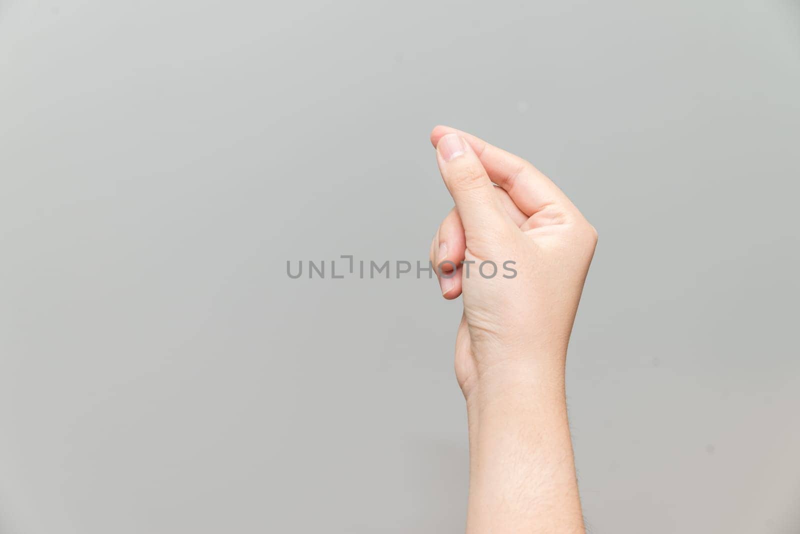 Human hand holding imaginary card on light gray background