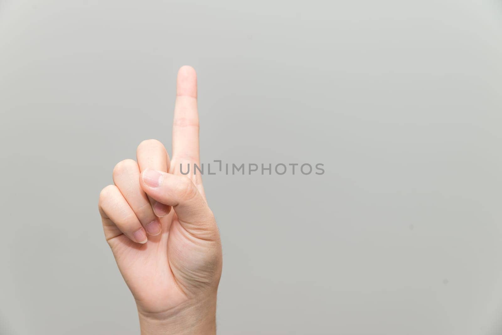 Human hand with one finger sticking up on light gray background