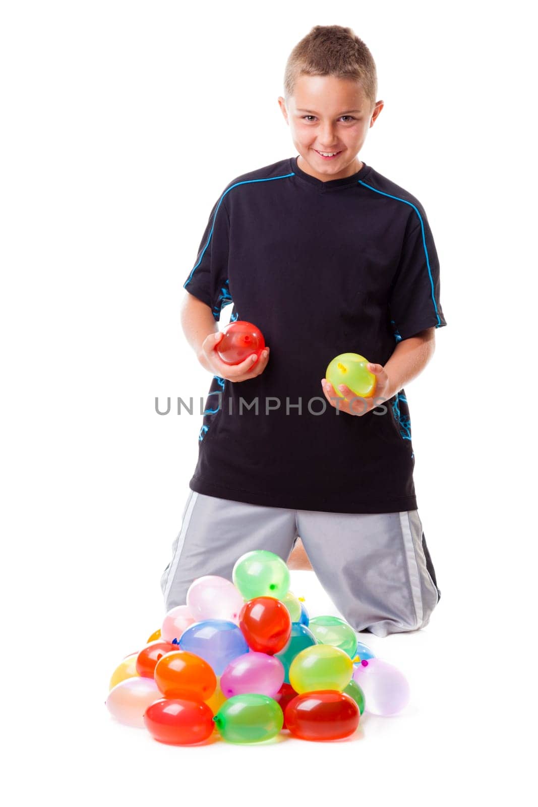 Boy with a pile of water balloons isolated on white background