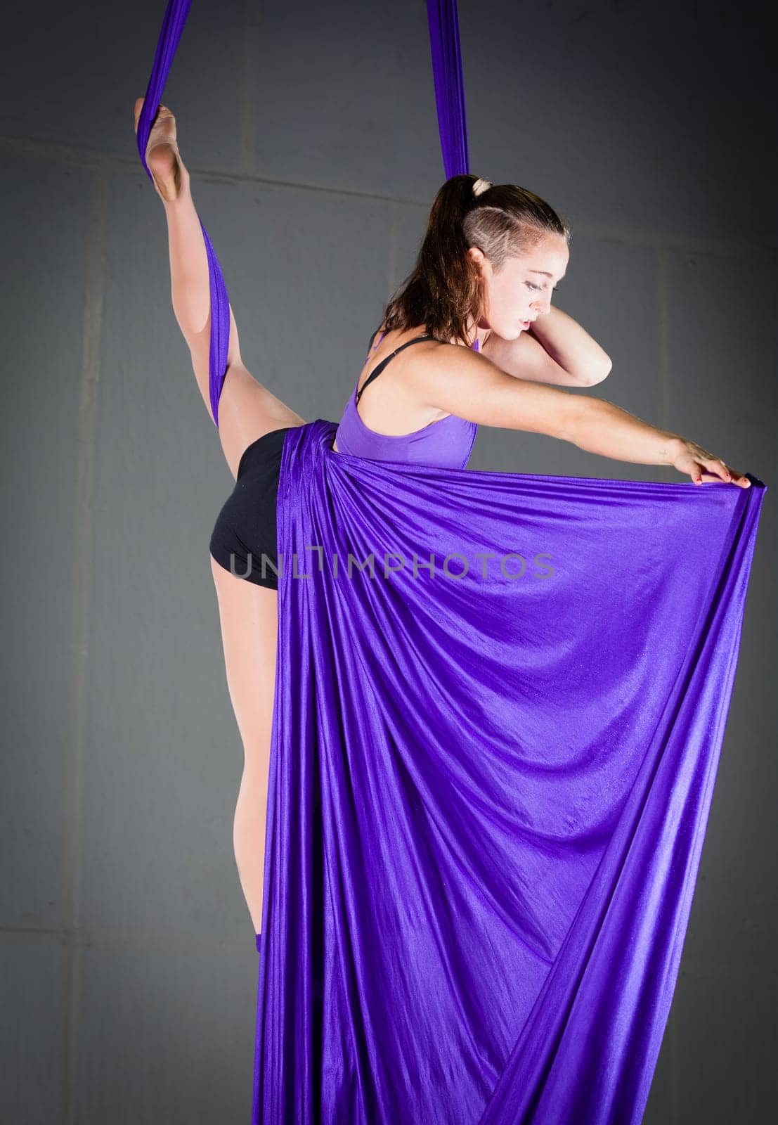 Beautiful woman gymnast performing aerial exercises