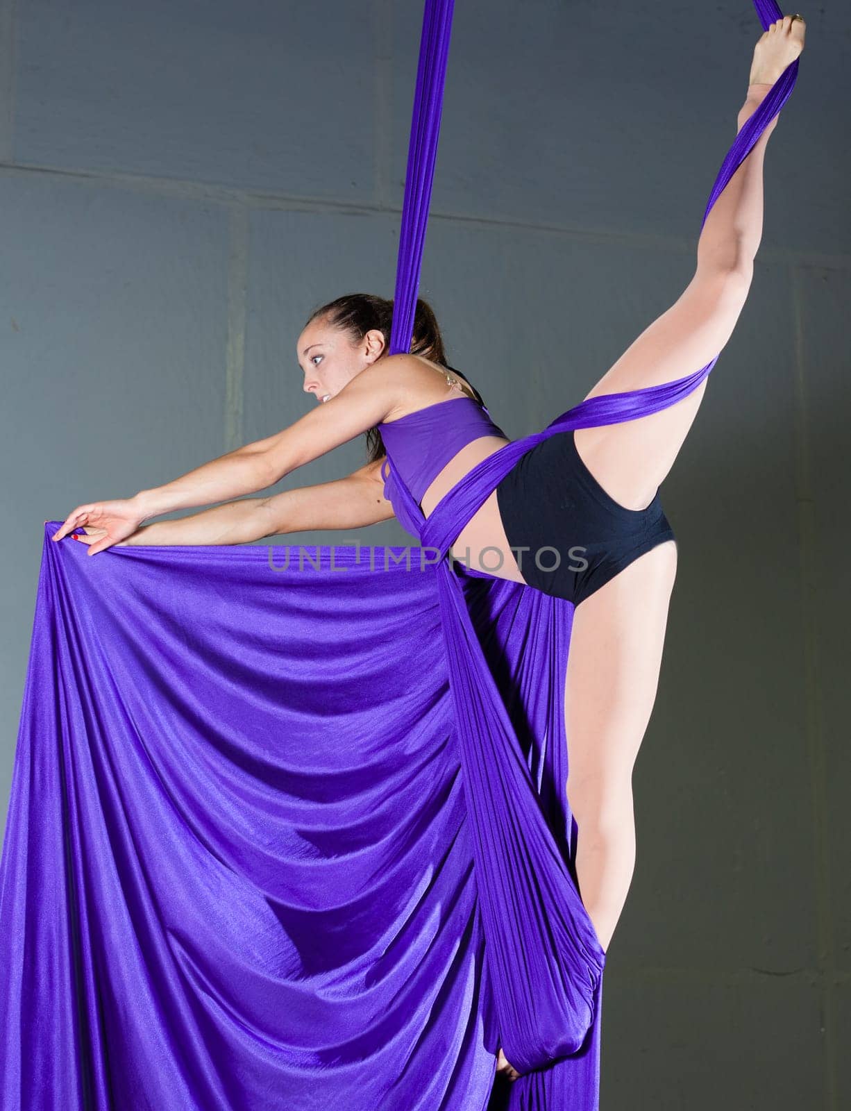 Beautiful woman gymnast performing aerial exercises