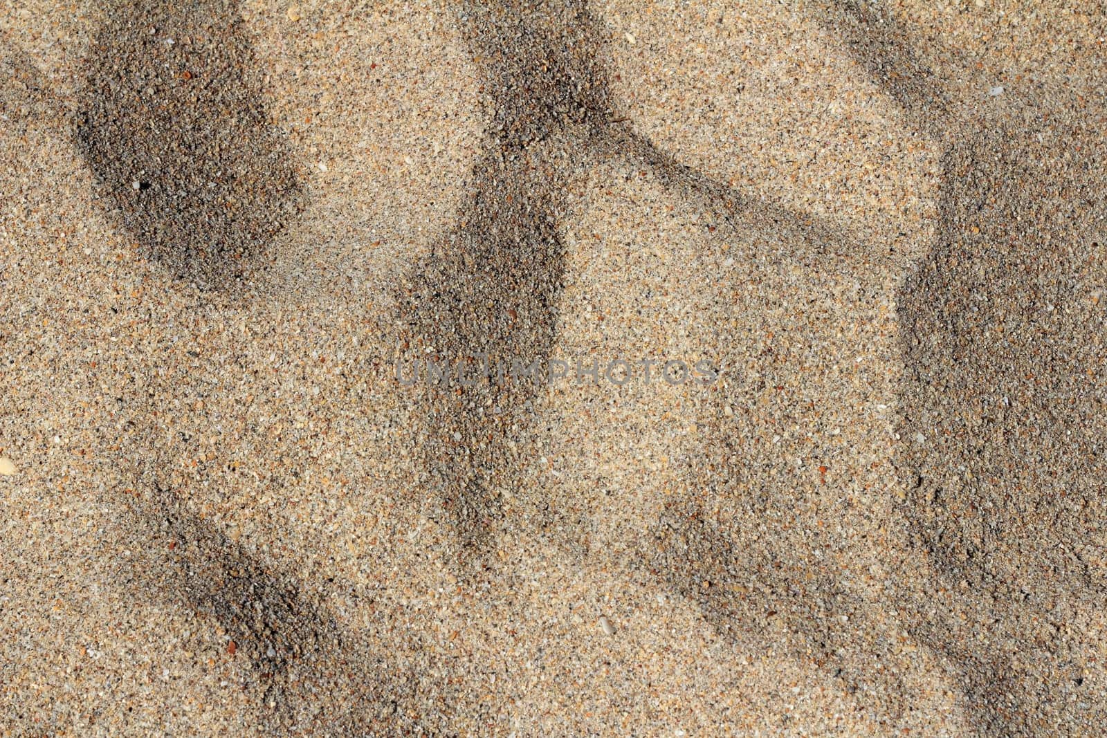 Fort Lauderdale, Florida closeup backdrop of fine grain brown sand with peaks and valleys on a sunny winter day.