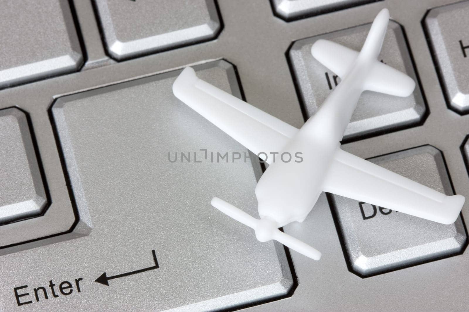 Plane on keyboard, to illustrate online booking or purchase of airline ticket