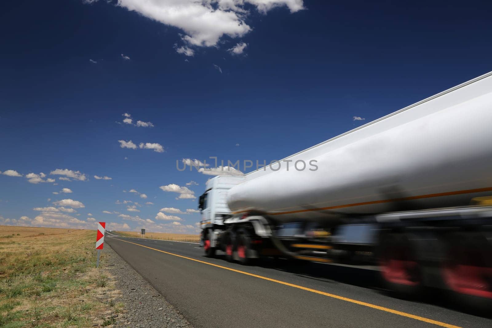 White tanker truck transporting fuel along the tar highway