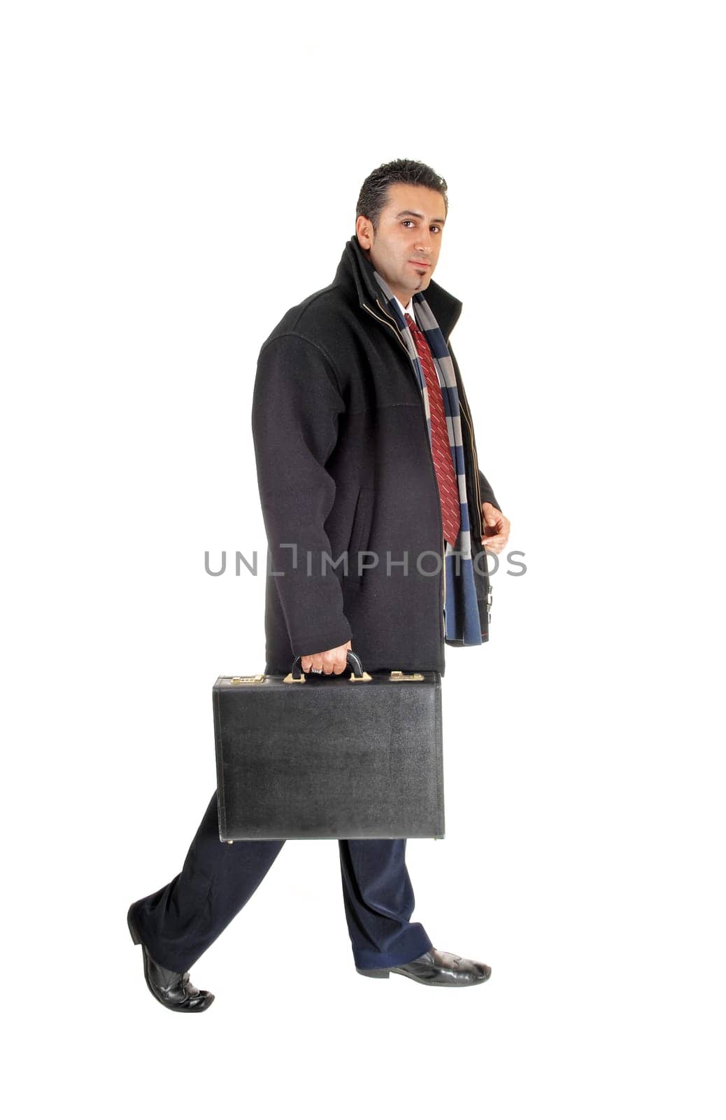 A handsome tall young businessman in a black coat with a .briefcase in his hand, walking, for white background..