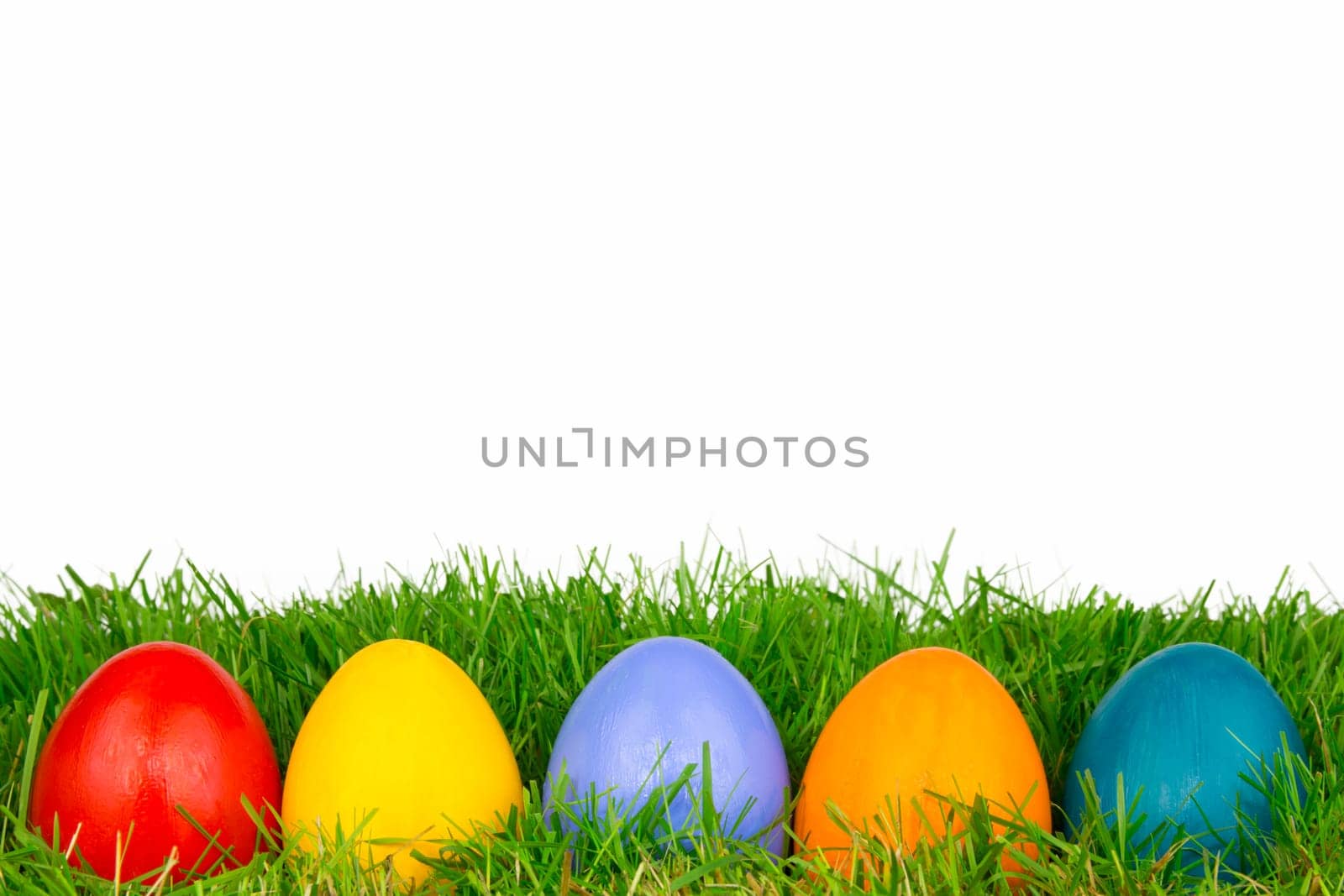 Colourful Easter eggs in a row on a meadow