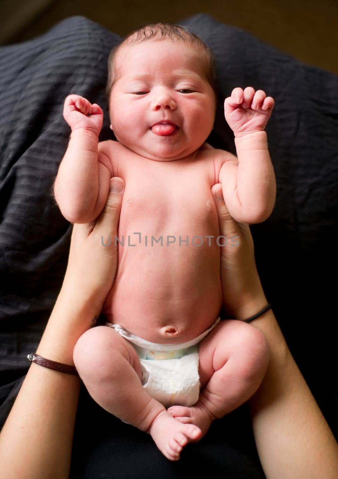Mother holds newborn baby girl preparing ro change her diaper