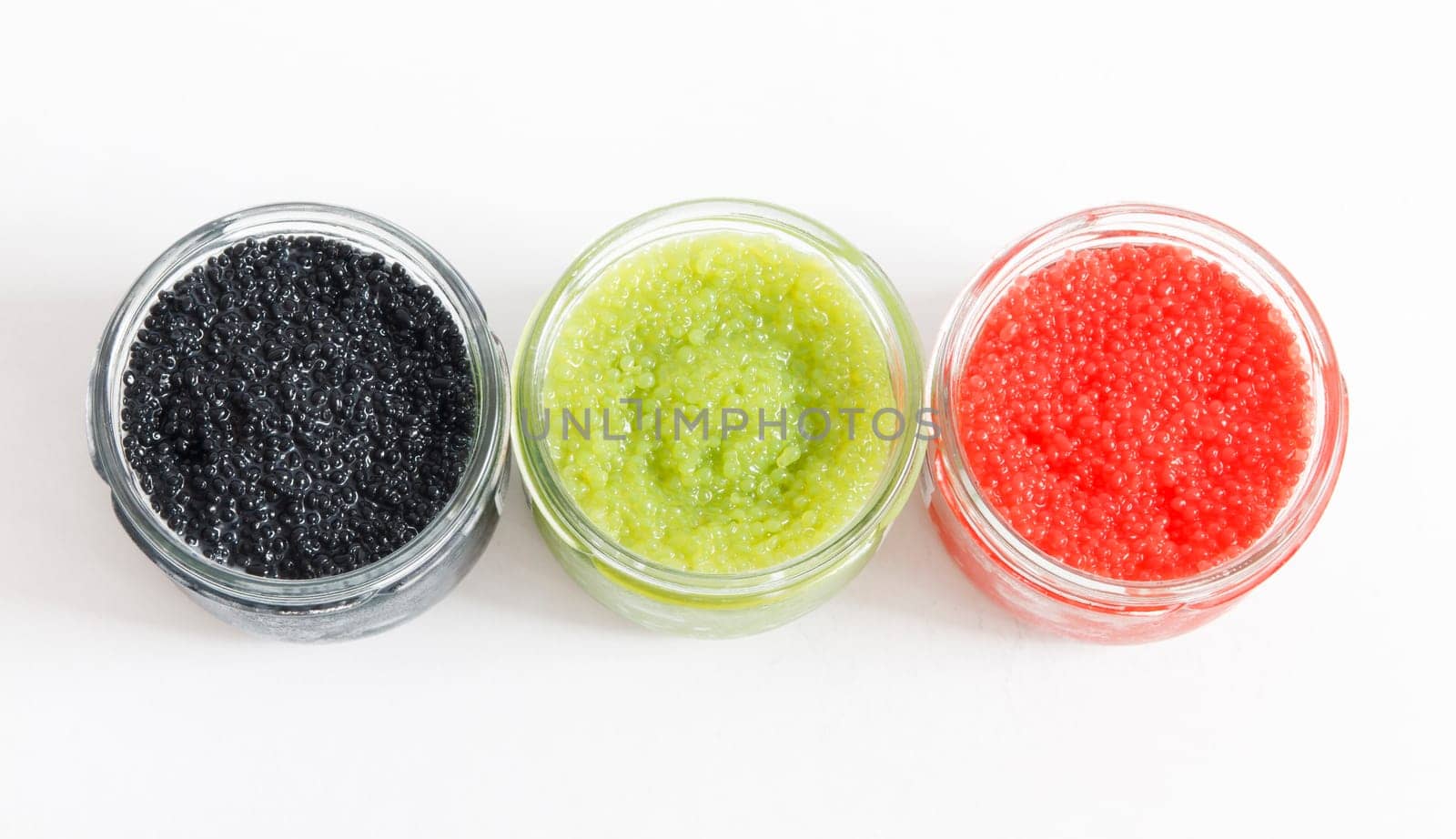 the red, green and black caviar in glass jars on withe background