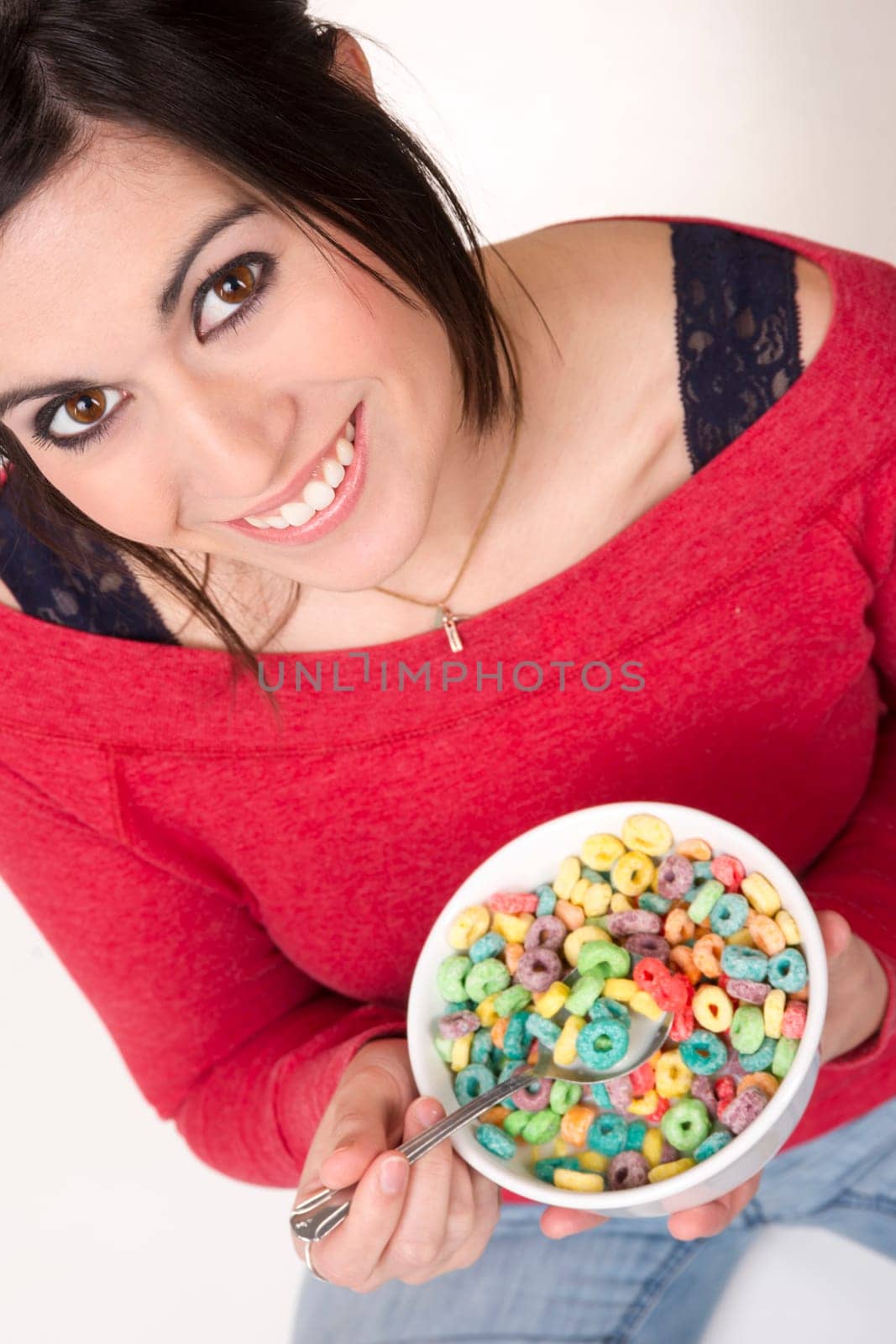 Female sits cross legged eating cereal in milk