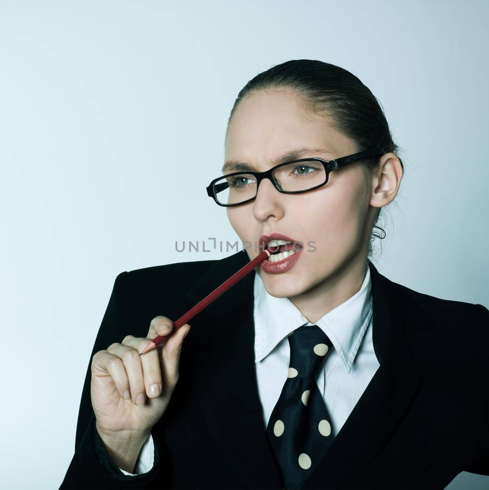 studio shot portrait of one business woman thinking chewing pen