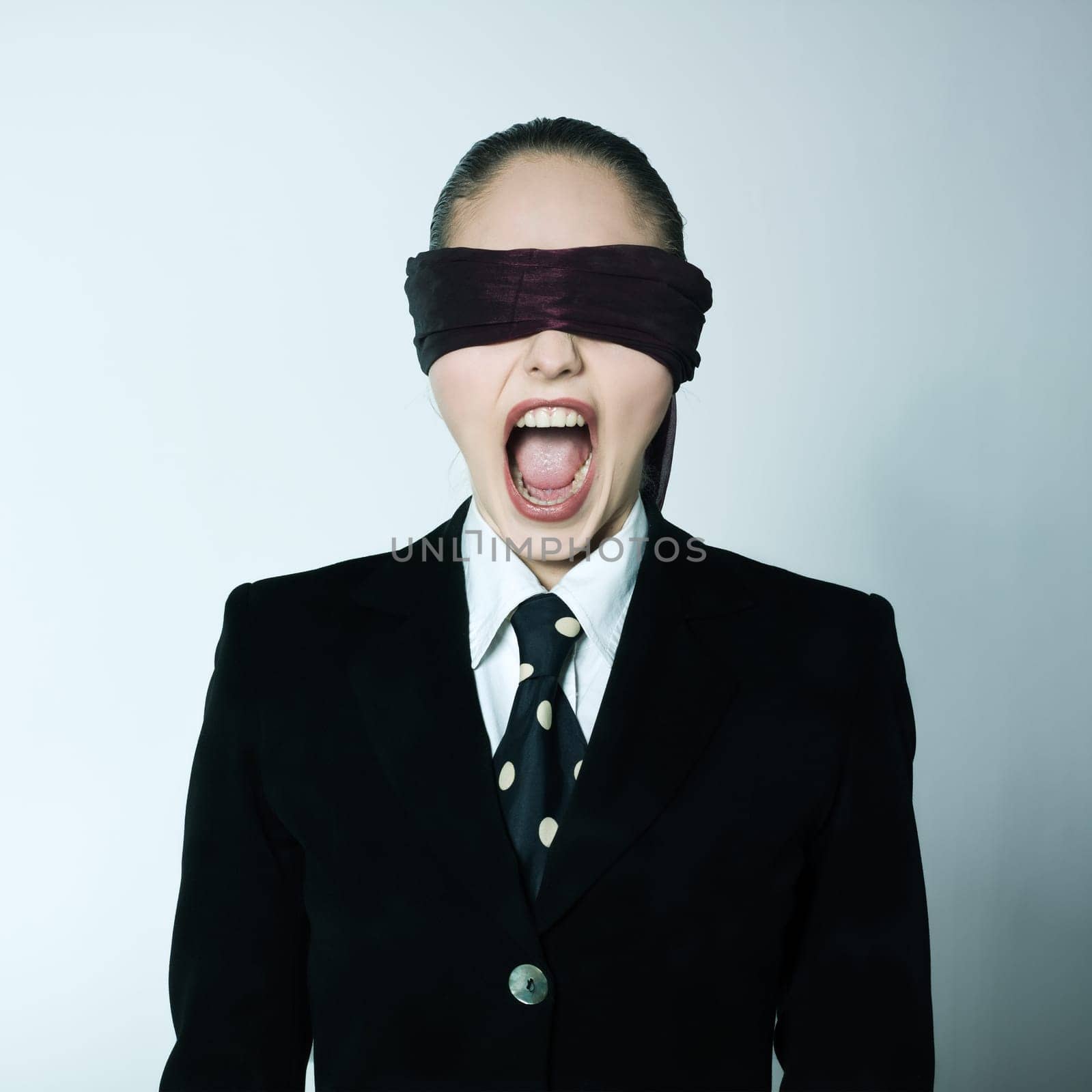 studio shot portrait of one caucasian young blindfold woman