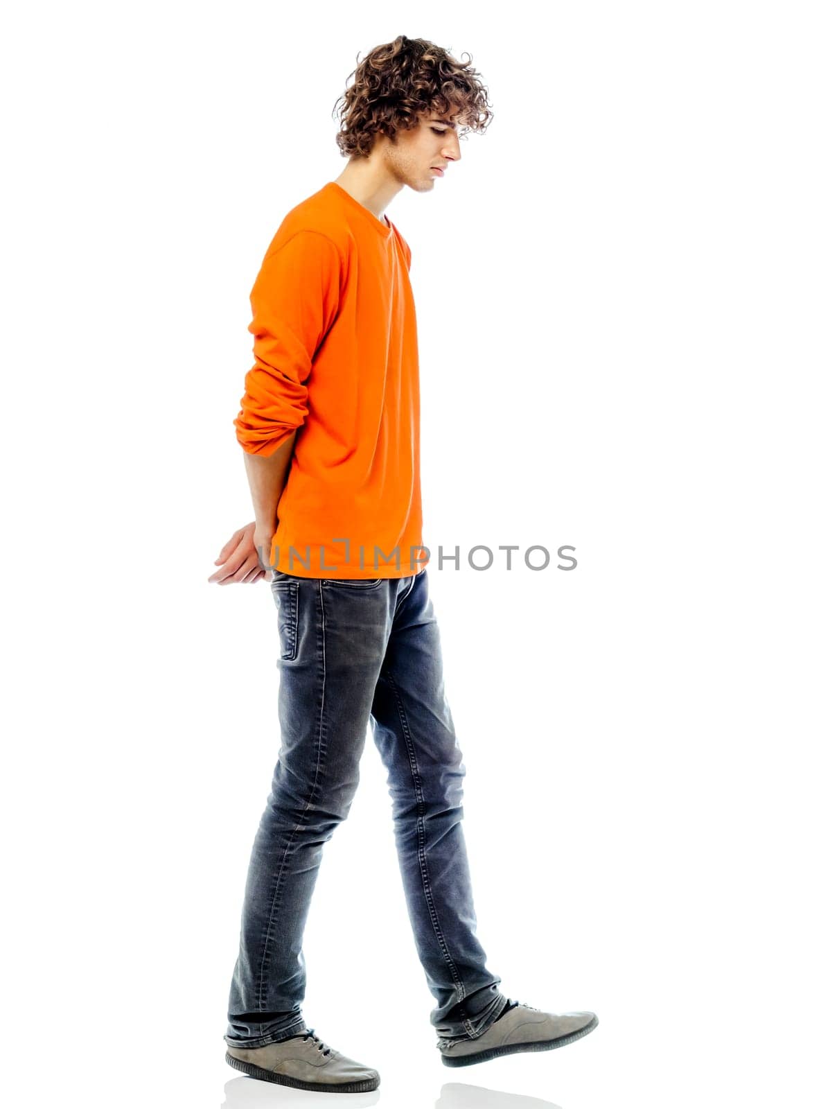 one young man caucasian walking sad bore side view  in studio white background